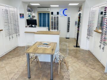 Moderní prodejna oční optiky - interiér s vystavenými brýlemi.